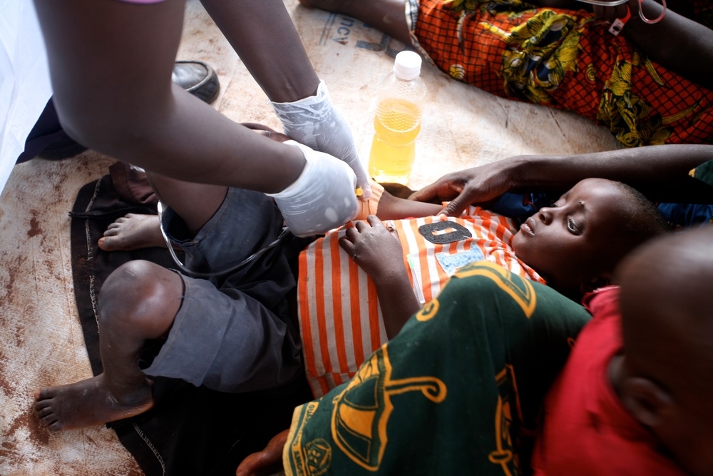 A Burundian refugee suspected of having cholera receives IV rehydration in the health clinic at Lake Tanganyika Stadium in Kigoma, Tanzania.