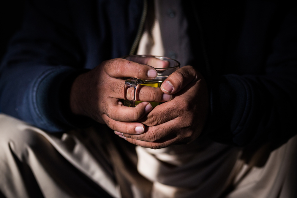 Hands around a cup of tea at a Kabul cafe