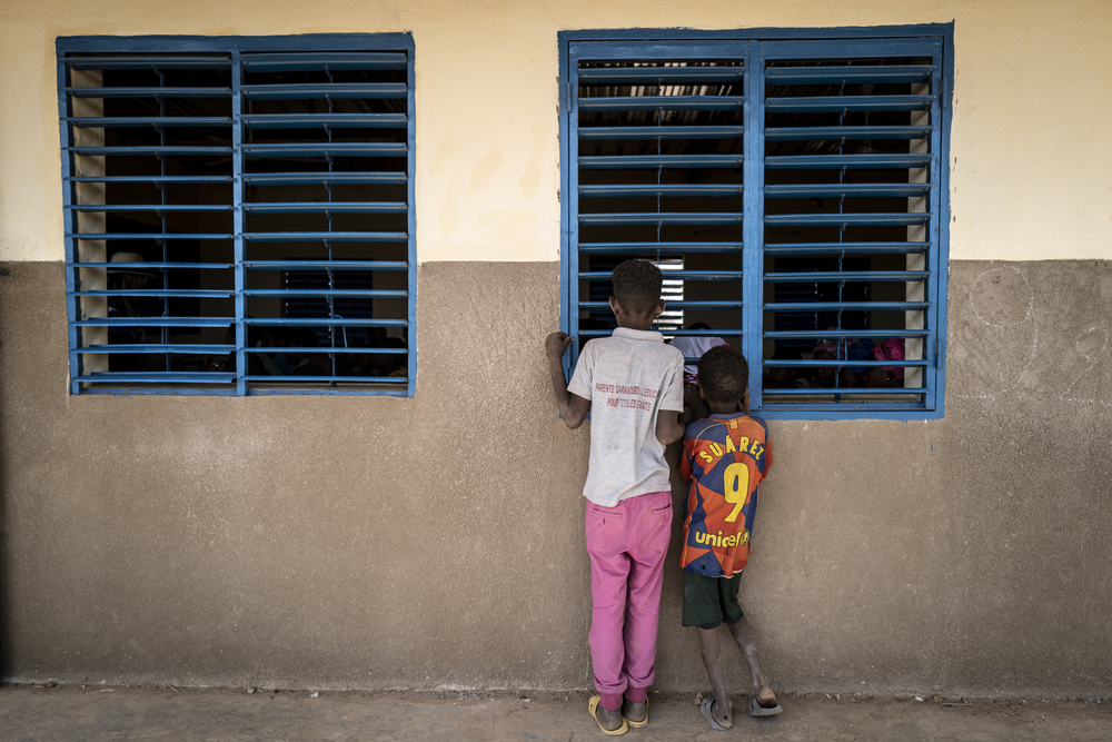 Deux enfants maliens réfugiés jettent un oeil dans un école