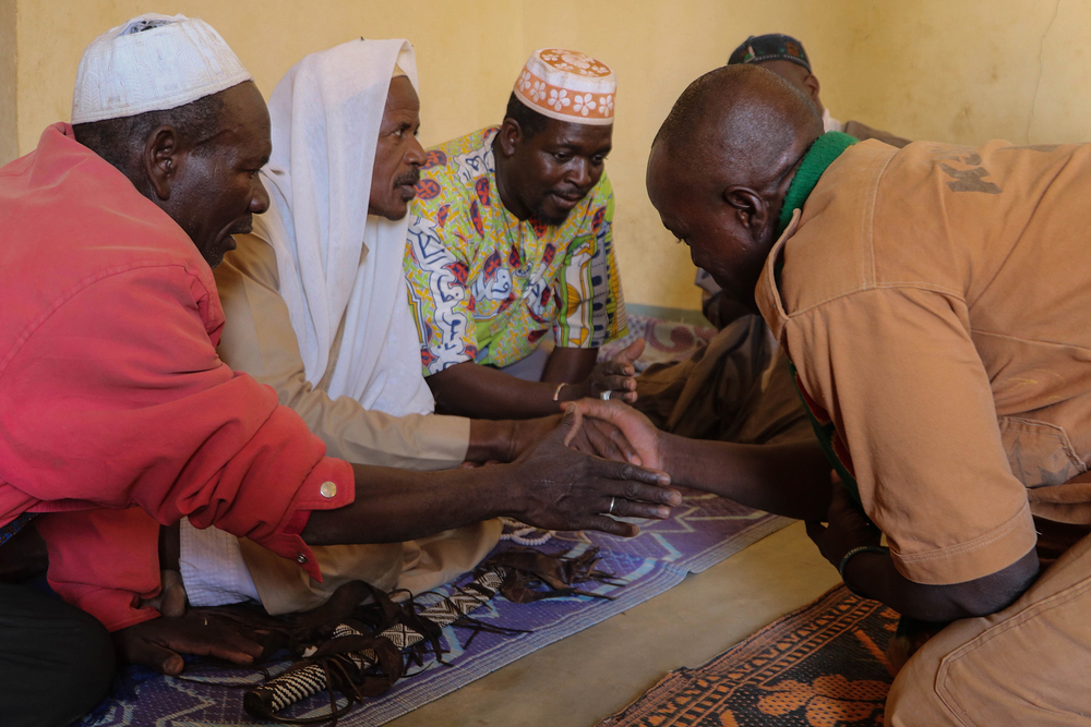 Image of Koglweogo members praying together and clasping hands in Burkina Faso’s Center-East region