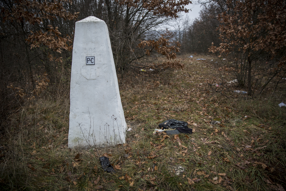 The border is marked by no more than a white, pyramid-shaped rock. On one side it says \