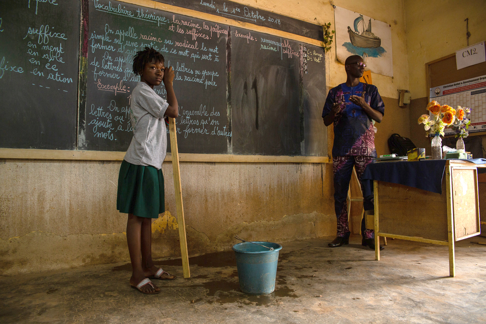 A teacher and a student in front of a chalk board