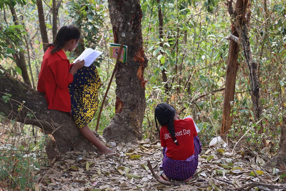 Two girls do classwork outside in Thantlang, in Chin State. In spite of intense military attacks, teachers have tried to keep classes going even in camps for displaced people.