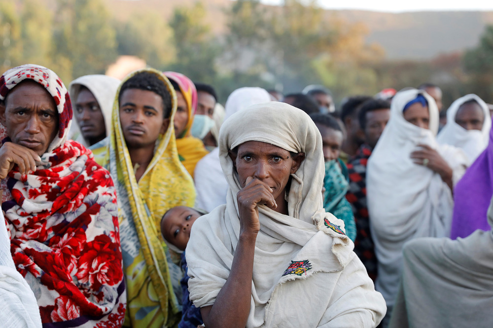 A woman stands in line to receive food donations, at a temporary shelter for people displaced by conflict, in the town of Shire, Tigray region, Ethiopia, 15 March, 2021.