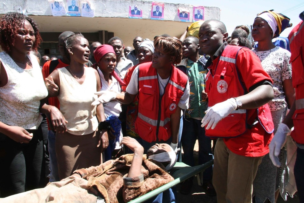 The Kenya Red cross team carries one of the casualties of the post election violence that has been on going in various parts of Kenya, Mathare slums, Nairobi, Kenya. 3 January 2008.