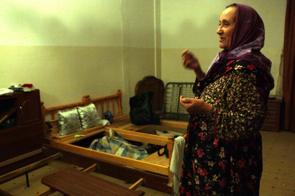 A resident of Sirte shows the destruction of bed frames and closets in her home after fighting between pro- and anti-Qaddafi forces