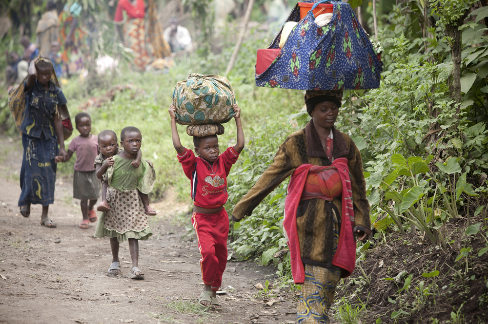 Congolese civilians carry their belongings as they escape the recent fighting between Congolese government forces and rebels close to Rutshuru in North Kivu in the east of the Democratic Republic of Congo on 20 May 2012