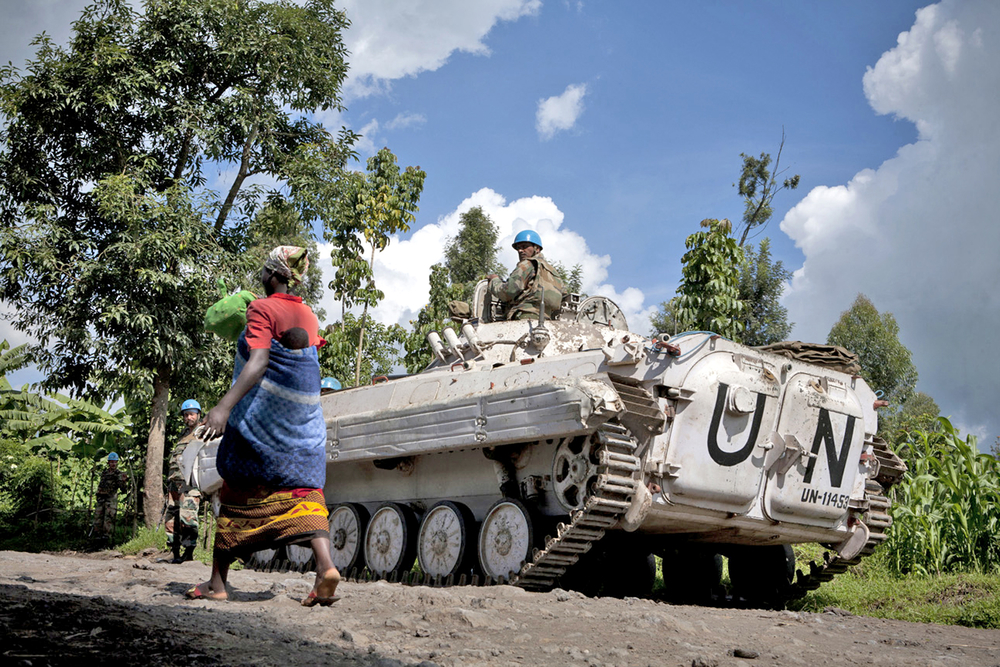 A Congolese woman and her child walk past a UN peacekeepers’ base near Bunagana, eastern DRC (May 2012)