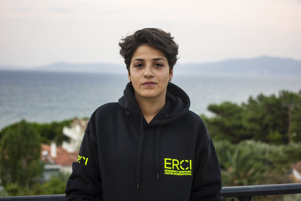 Portrait of a young woman in a hooded sweatshirt on a balcony