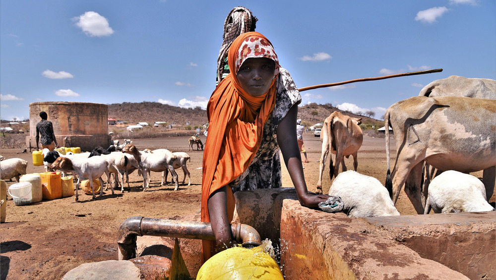 A woman fills a jerry can at a watering point in Kulu Mawe.