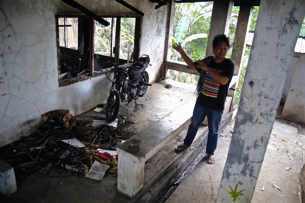 Rius Valle shows a firebombed building at the church sheltering displaced indigenous people in Davao City