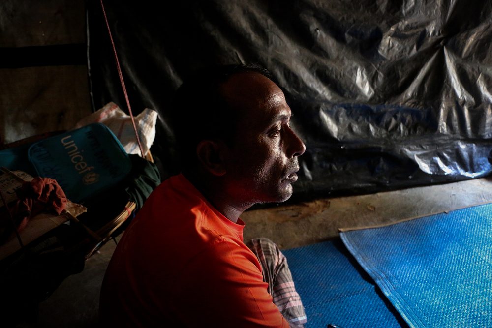 Photo of a man in a dark room in Bangladesh refugee camp