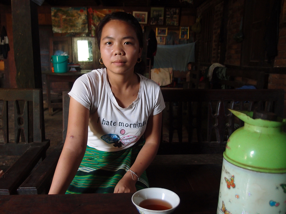 Portrait of young person in Myanmar with tea and a shirt that says