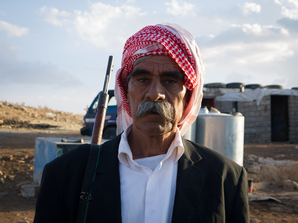 A Yadizi man on top of Mount Sinjar with a rifle slung on his shoulder