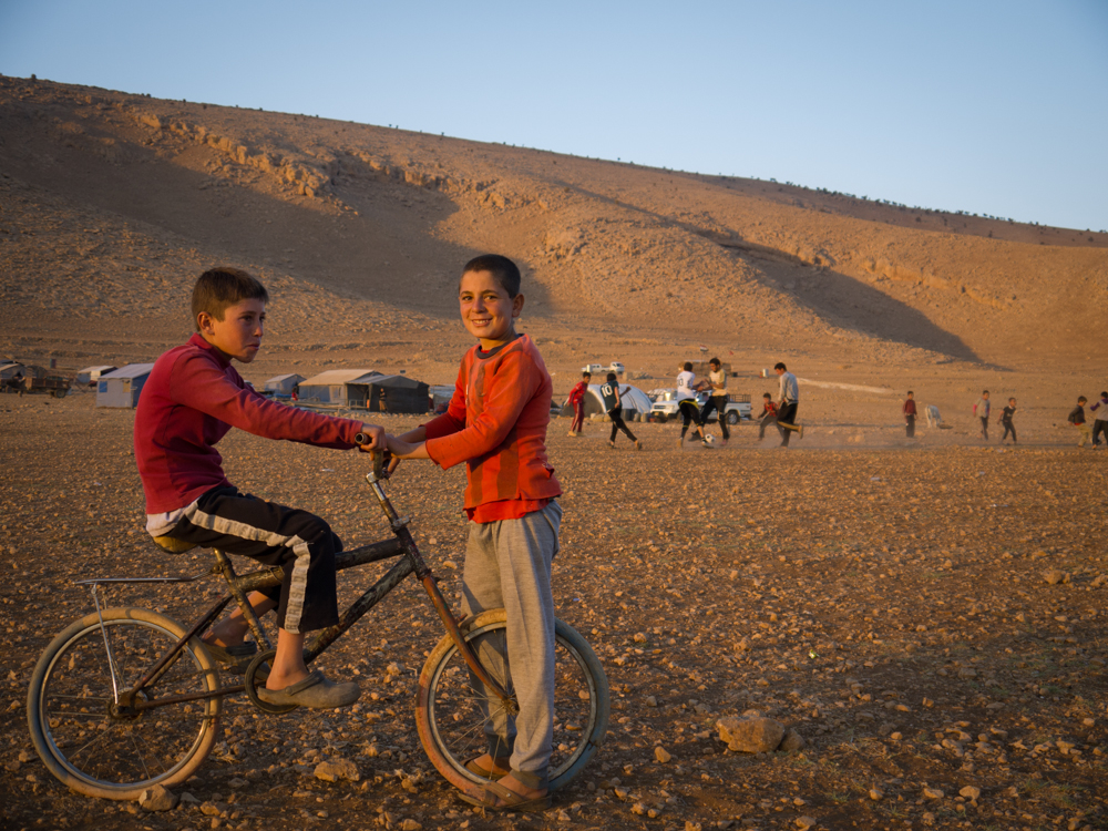 Children play on top of Mount Sinjar as the sun sets