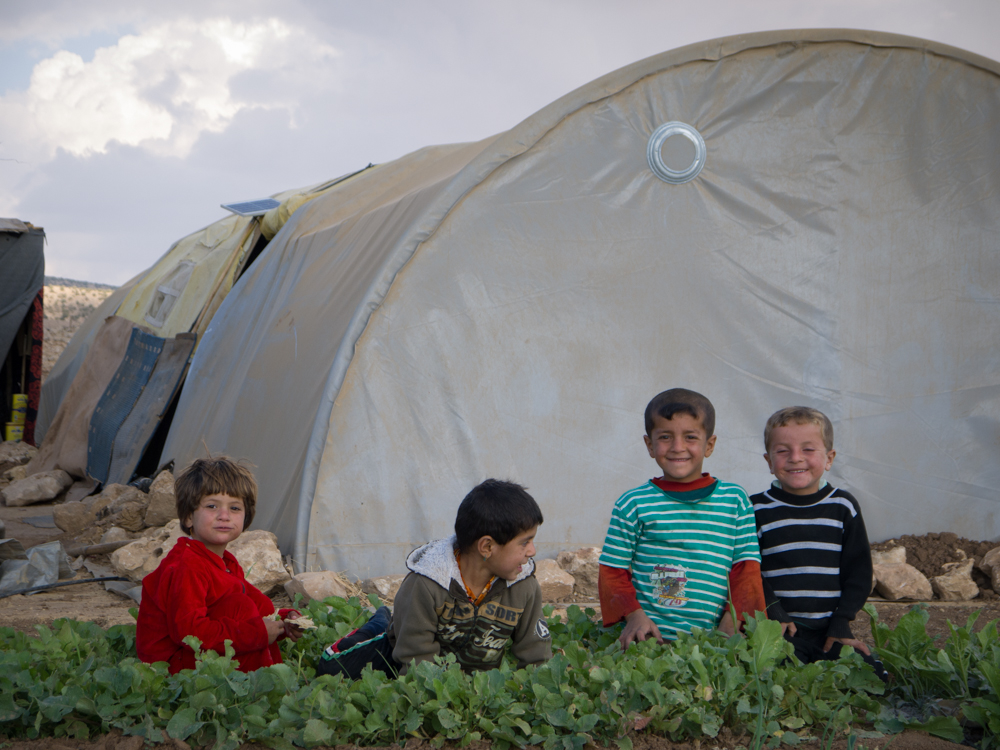 Yazidi children in front of a small garden on top of Mount Sinjar