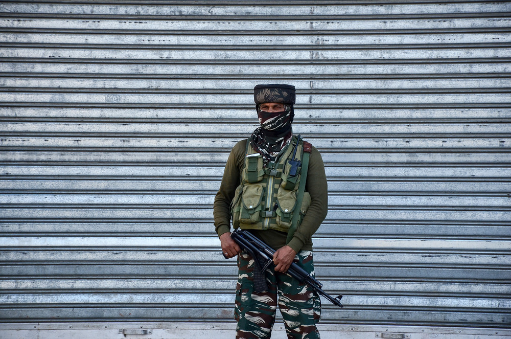A paramilitary trooper wearing a face mask stands at a closed market during coronavirus lockdowns in Srinagar on 30 May, 2021.