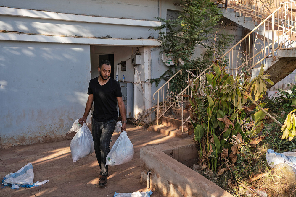 Tarig Hlme, a sales executive and member of a resistance committee, distributes bags of food to poor families and street vendors in Khartoum.