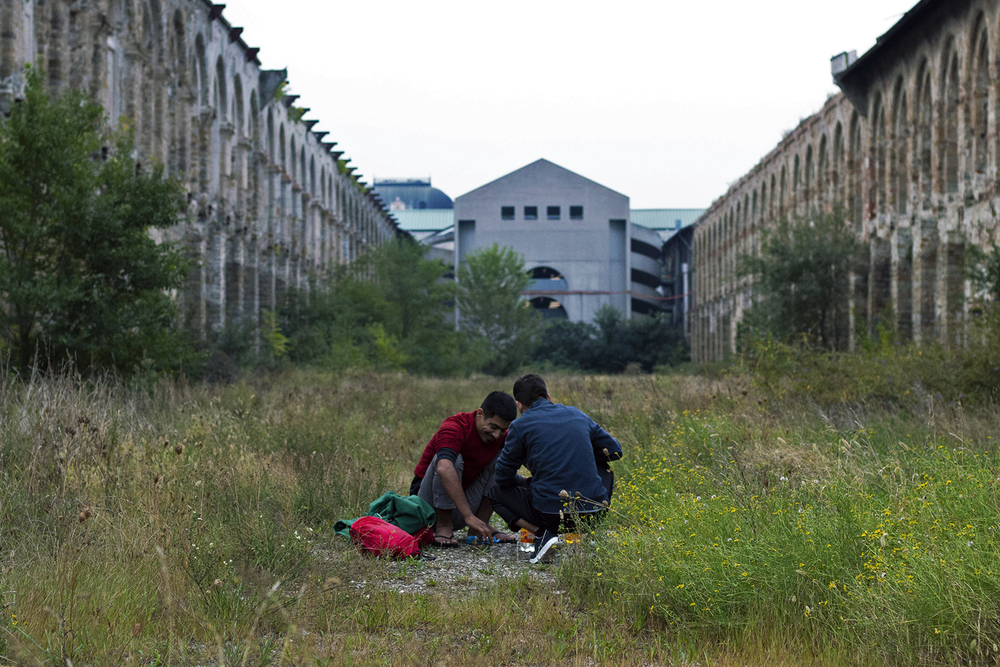 Two Afghan refugees outside an abandoned building near the Trieste train station