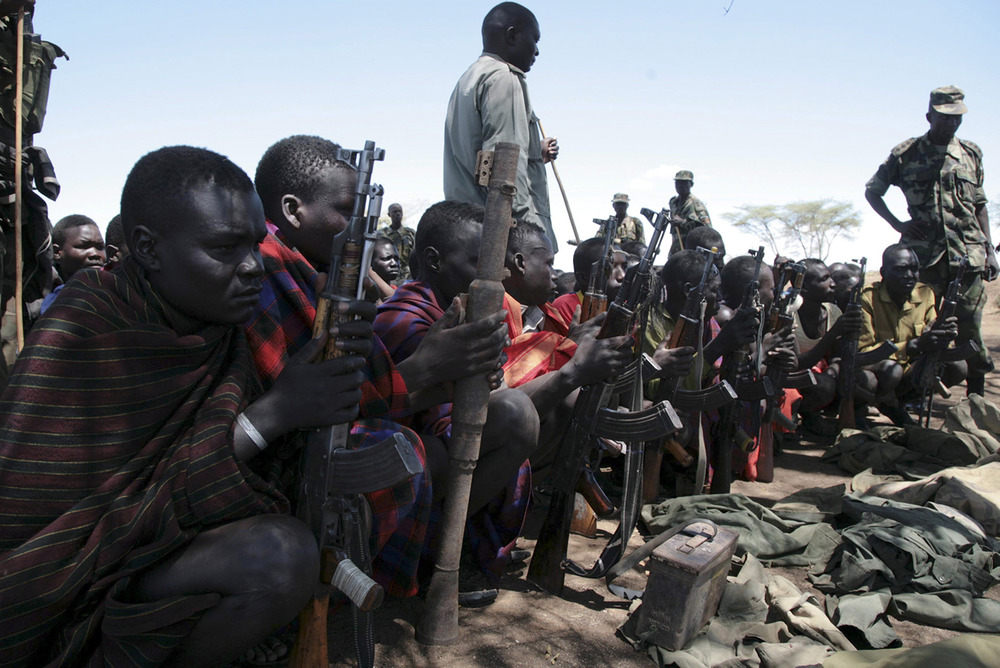 Karamojong warriors sit with their weapons during a 'cordon and search' operation by the Ugandan army in 2007. A new disarmament campaign is under way.