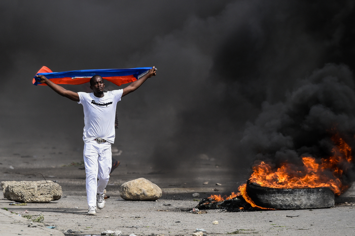 A demonstrator waves a Haitian flag during a protest outside United Nation's main base, against President Jovenel Moise on October 4, 2019 in Port-au-Prince, Haiti.