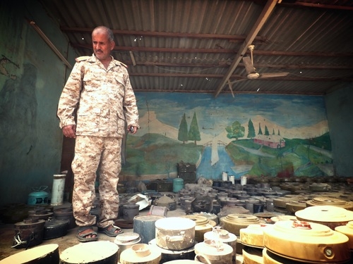 Shiek Zaid Tabet, head of the Mine Action Programme in Aden, stands amid some of the land mines found by his teams since mid-July in Yemen
