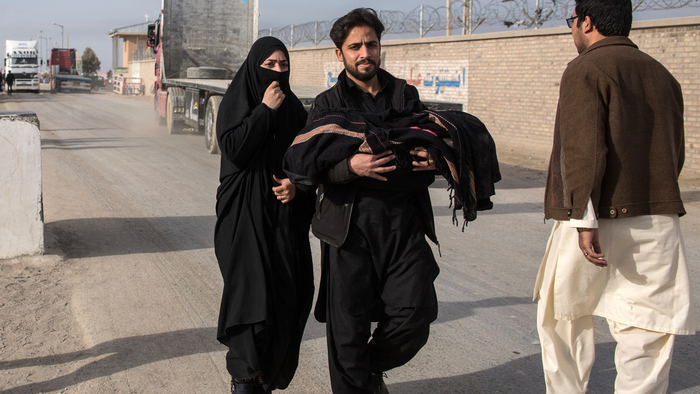 Afghan returnees walk across the Iranian border into Zaranj, Nimruz.