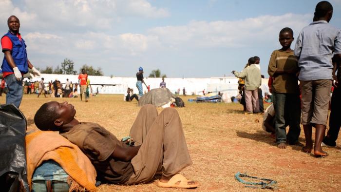 A Burundian refugee dozes in the midday sun at the Lake Tanganyika Stadium, a temporary transit camp for refugees in Kigoma, Tanzania. Tens of thousands of people have been fleeing Burundi amid rising political tensions and a failed coup ahead of election