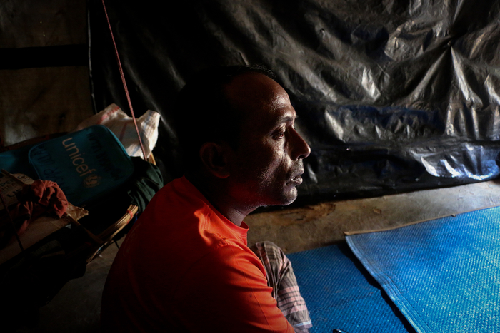 Photo of a man in a dark room in Bangladesh refugee camp