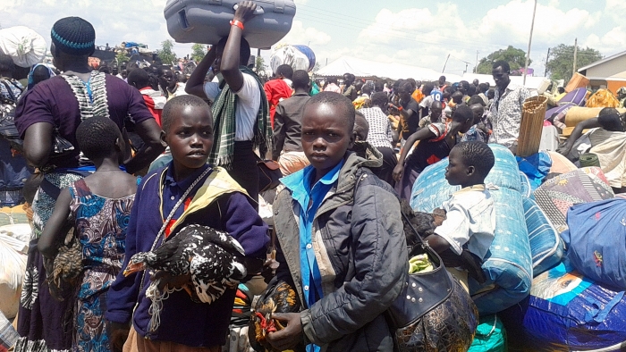 South Sudanese refugee boys holding chickens on arrival in Uganda