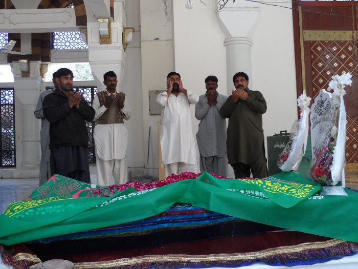 Devotees pray at the burial chamber in the Bari Imam Sufi shrine in Islamabad