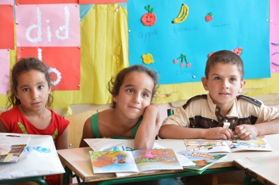 Saadnayel public school - Bekaa/Lebanon. Three Syrian children are looking and listening attentively to their teacher