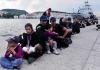 Migrants and asylum seekers queue up at Mytilene Port on the Greek island of Lesvos waiting for police clearance.