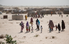 Approaching the militarised “red zone” towards the border with Niger, displaced families gather for another distribution of cash handouts.