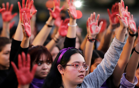 Women raise their hands as they protest against gender violence and femicide in Puebla, Mexico on 22 February 2020.