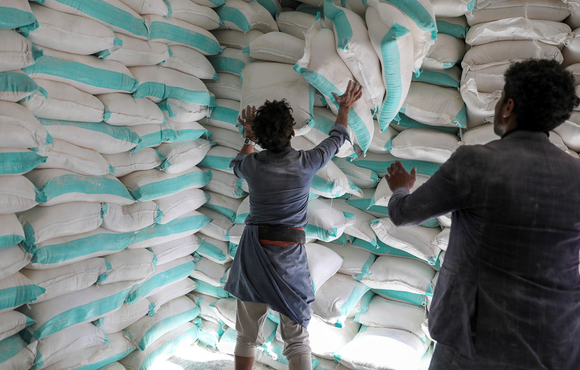 Workers handle sacks of wheat flour at a World Food Programme distribution centre in the Yemeni capital of Sana'a.