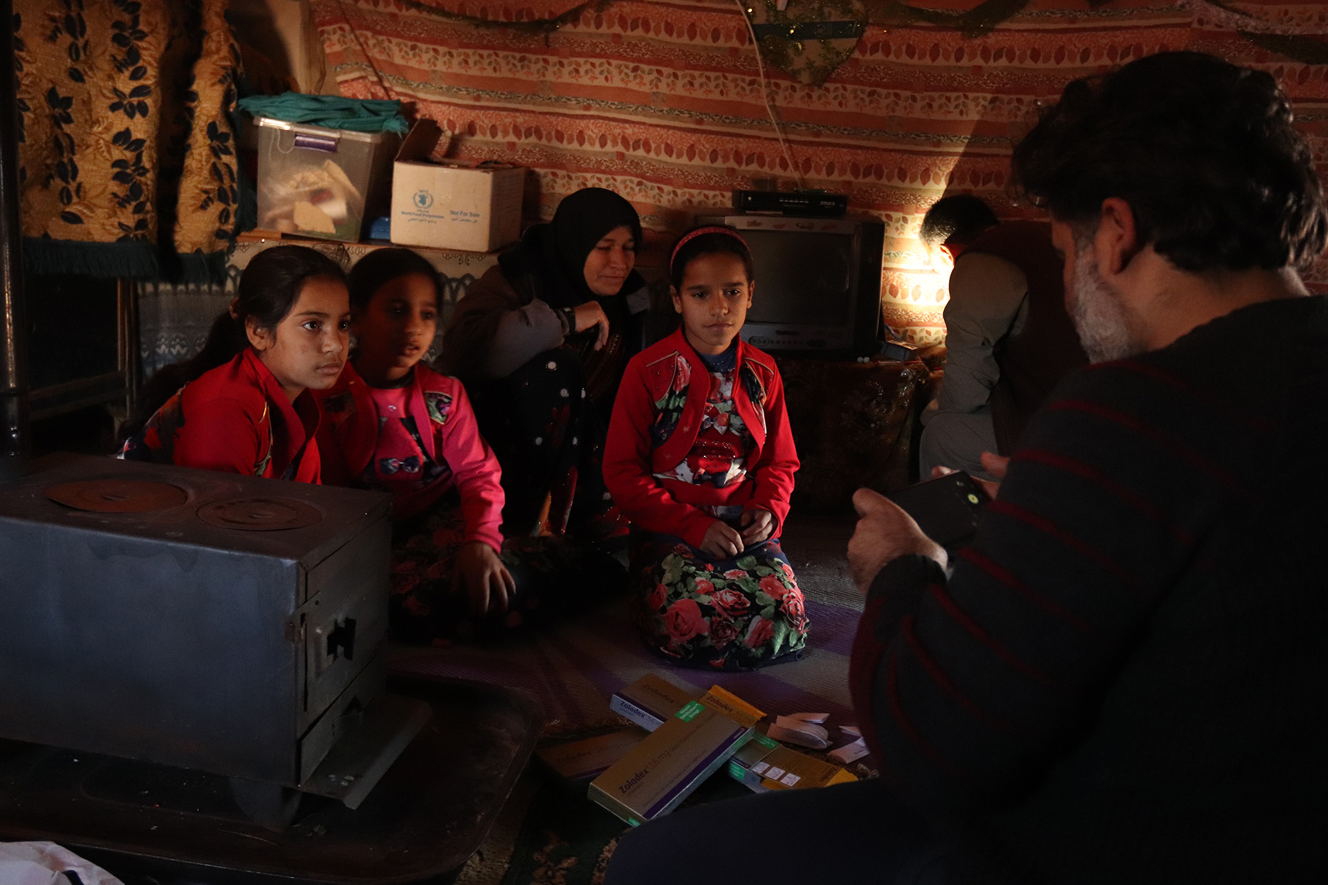 Pharmacist Ahmad Mustafa lays out boxes of free medication he had brought for Mhassen Suleiman and her four daughters, who live in a makeshift tent in the town of Sarmada, near the Turkish border.