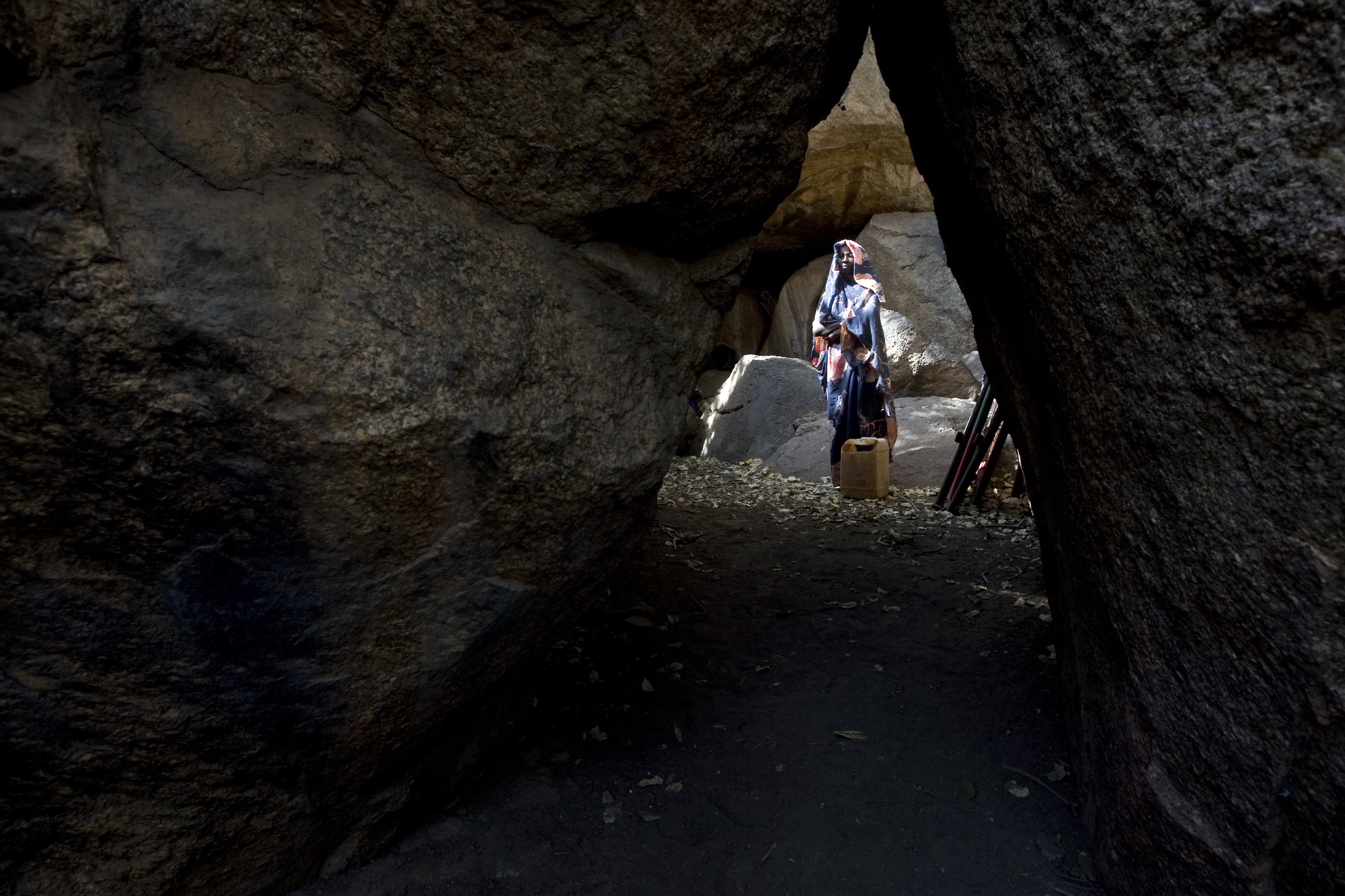 A Nuban woman hides in a cave
