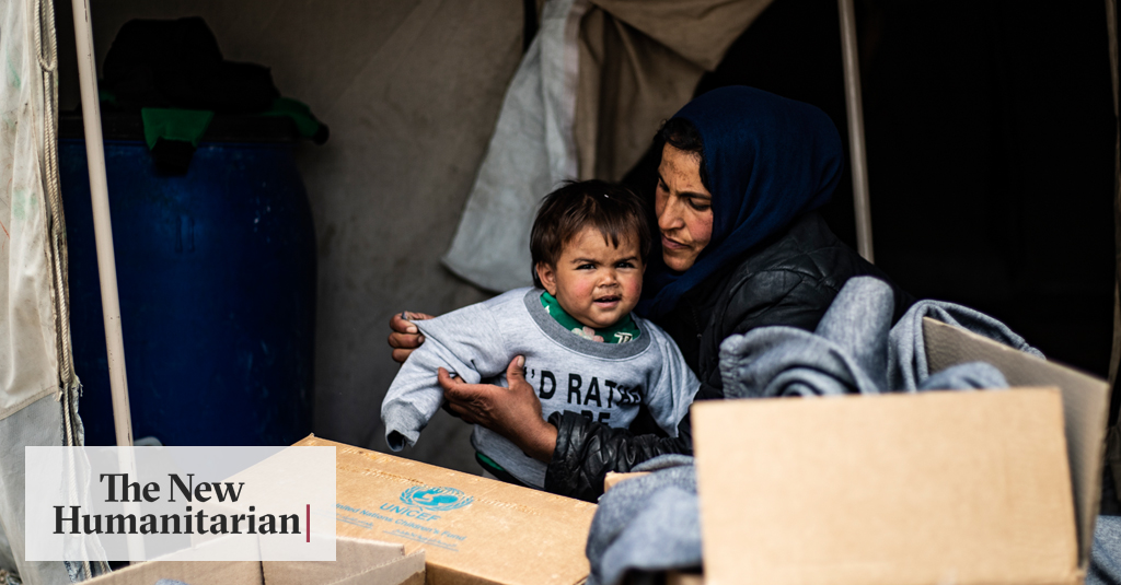 Mariam, who fled rural Aleppo two years ago with her husband and family, helps one of her six children try on new winter clothes delivered to Ain Issa camp, northeastern Syria.