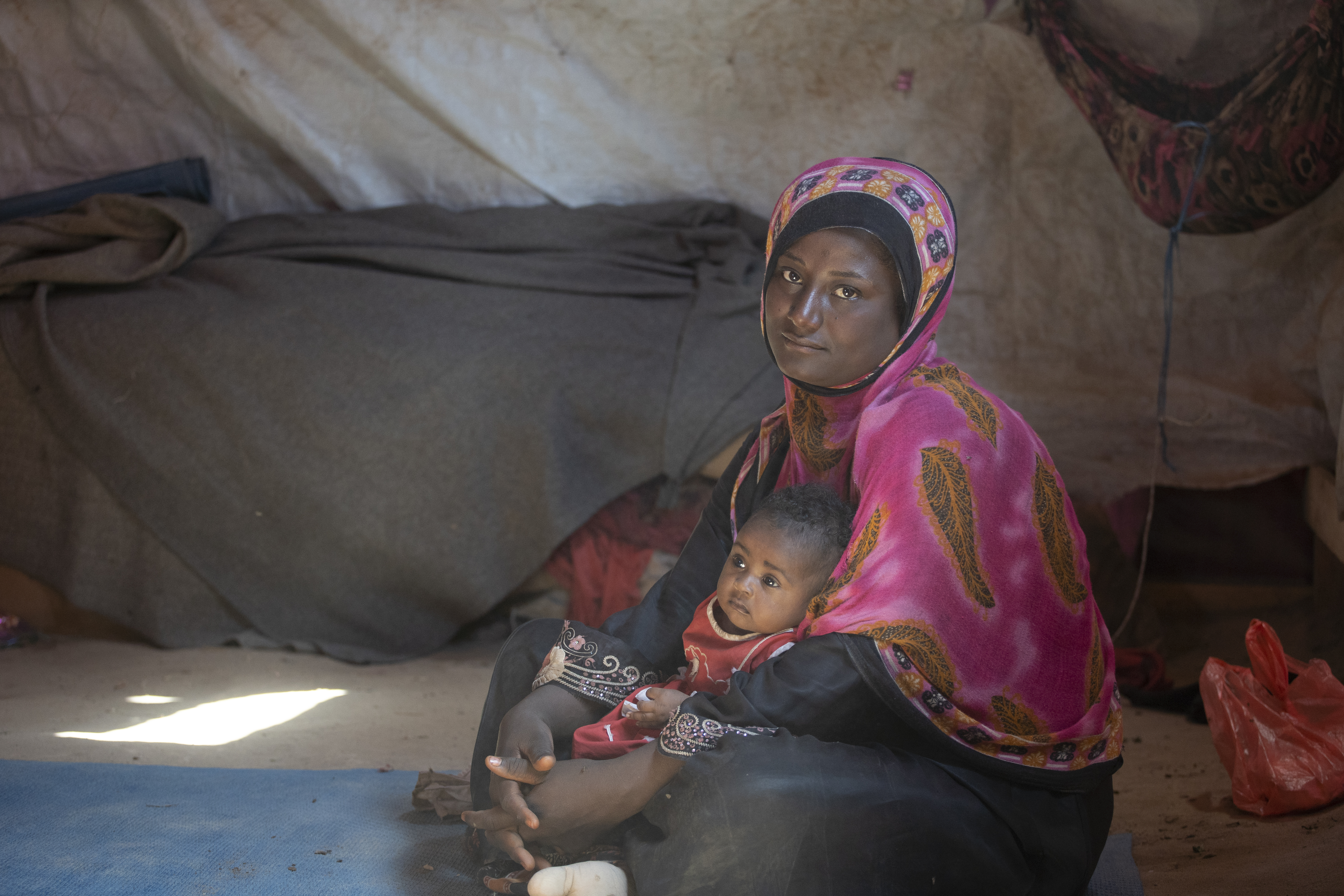 Photo of woman in Yemen with her child in a displacement camp.