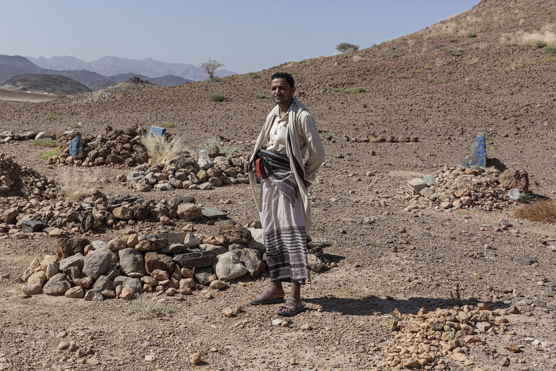 People smuggler Ahmed al-Awlaqi stands in a small cemetery where he buries migrants just outside Ataq.