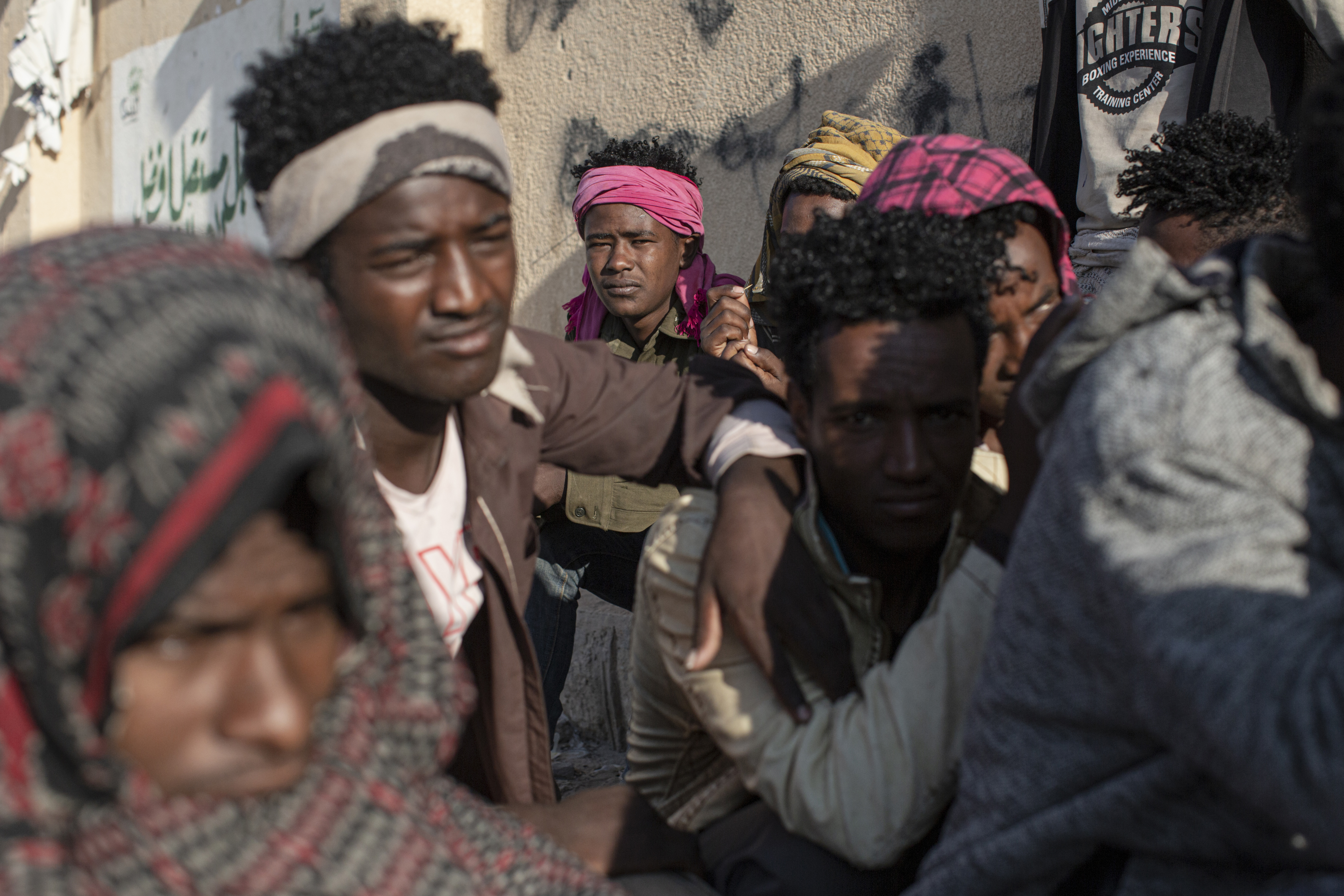 Abdul Karim Trat (21, centre), from Ethiopia, sits by the roadside in Ataq, 16 November 2020.