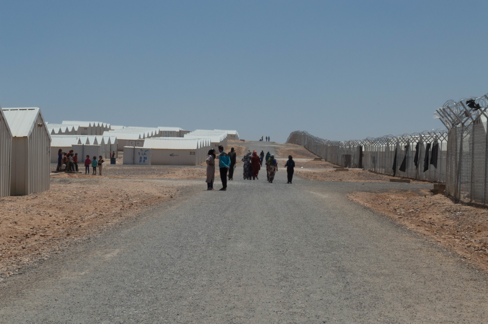 Barbed wire fence and white shelters