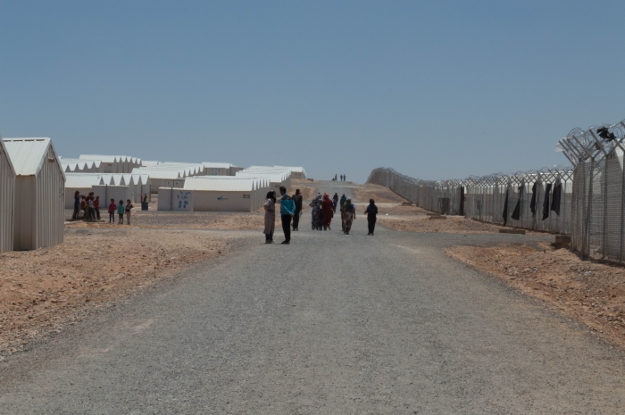 Barbed wire fence and white shelters