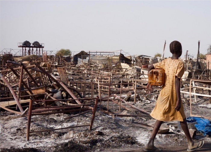 Girl walks through the ruins of Malakal PoC destroyed in fighting