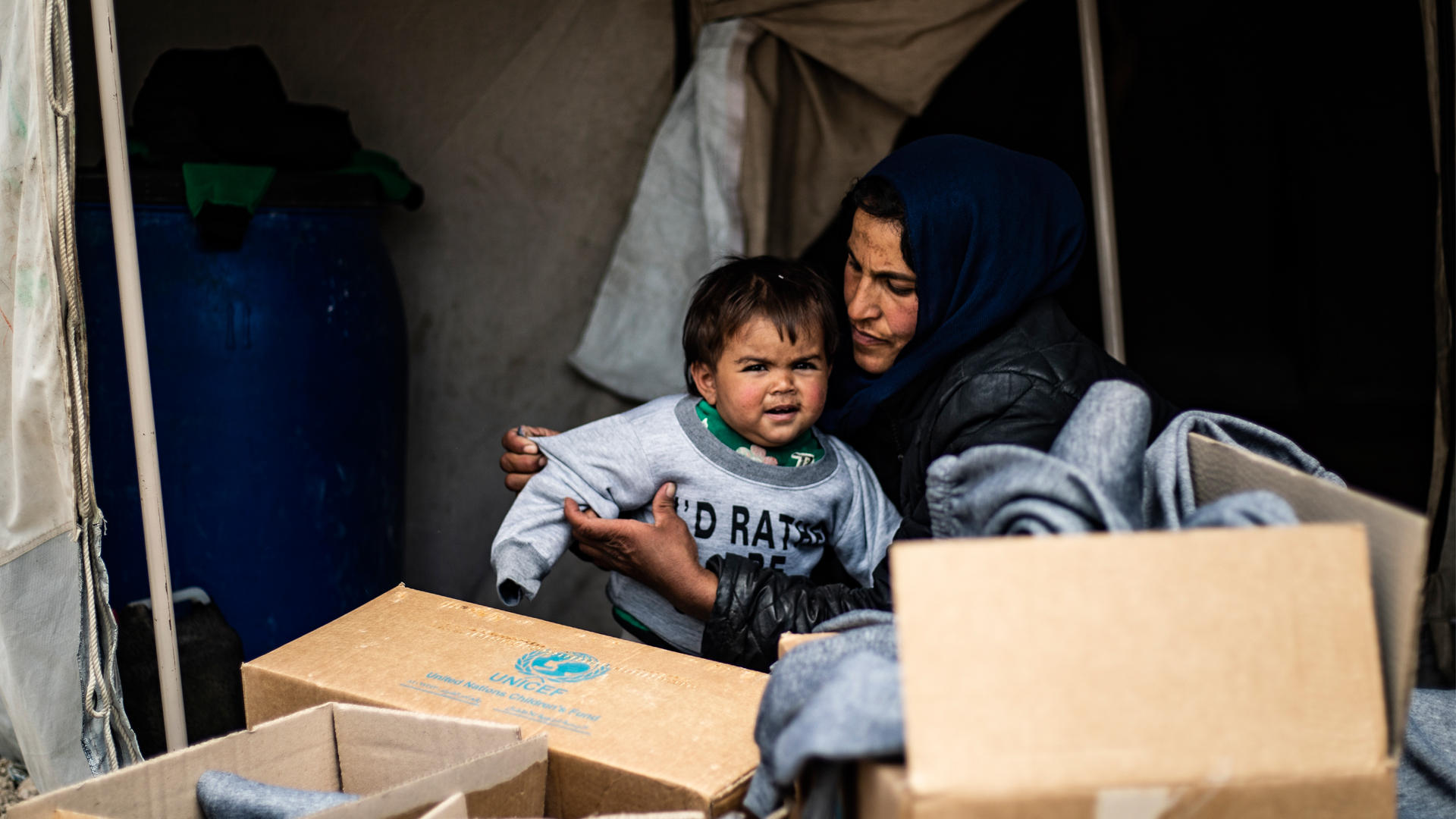 Mariam, who fled rural Aleppo two years ago with her husband and family, helps one of her six children try on new winter clothes delivered to Ain Issa camp, northeastern Syria.