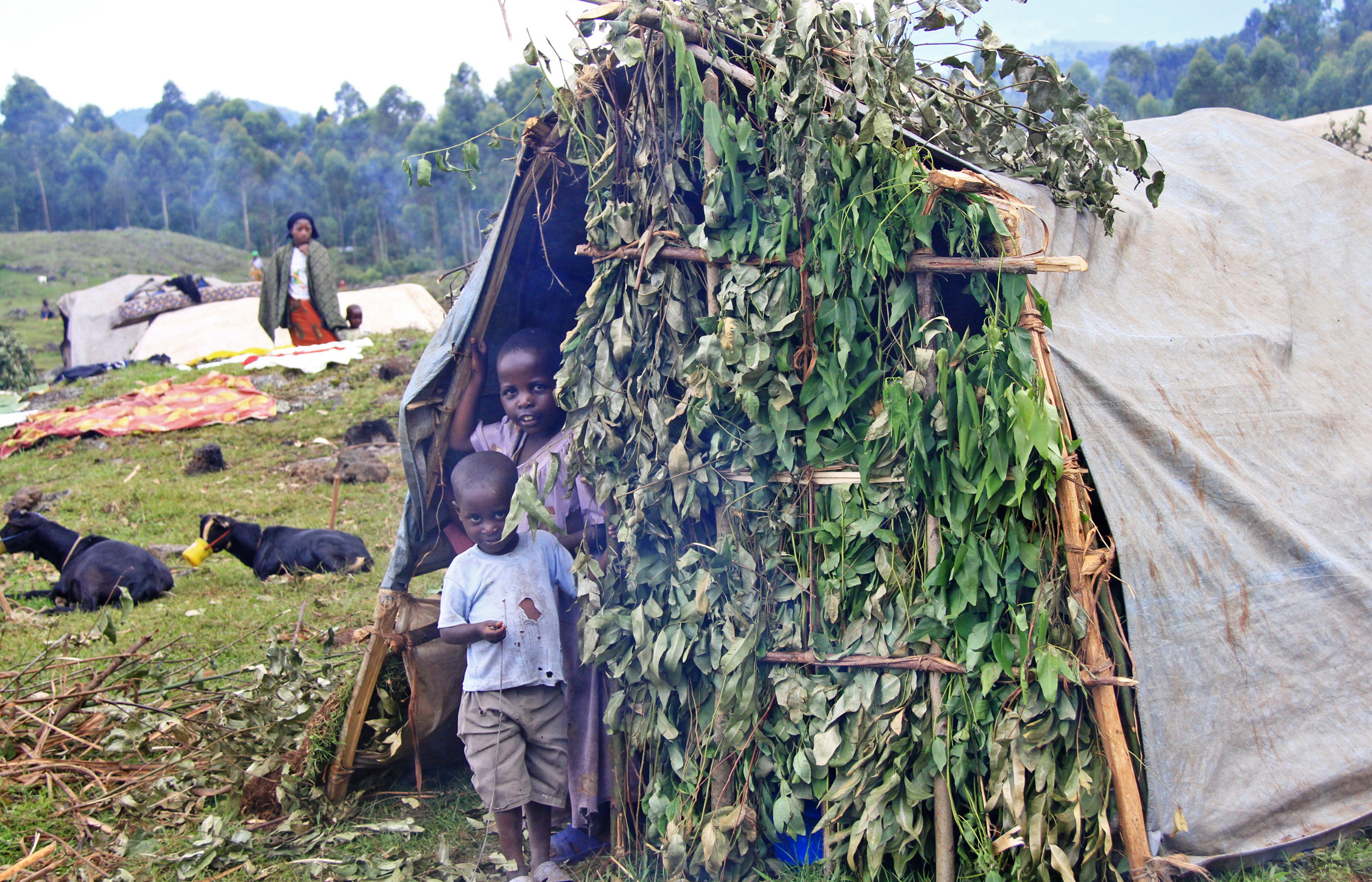 Congolese refugee children stand in front of their shelter at 