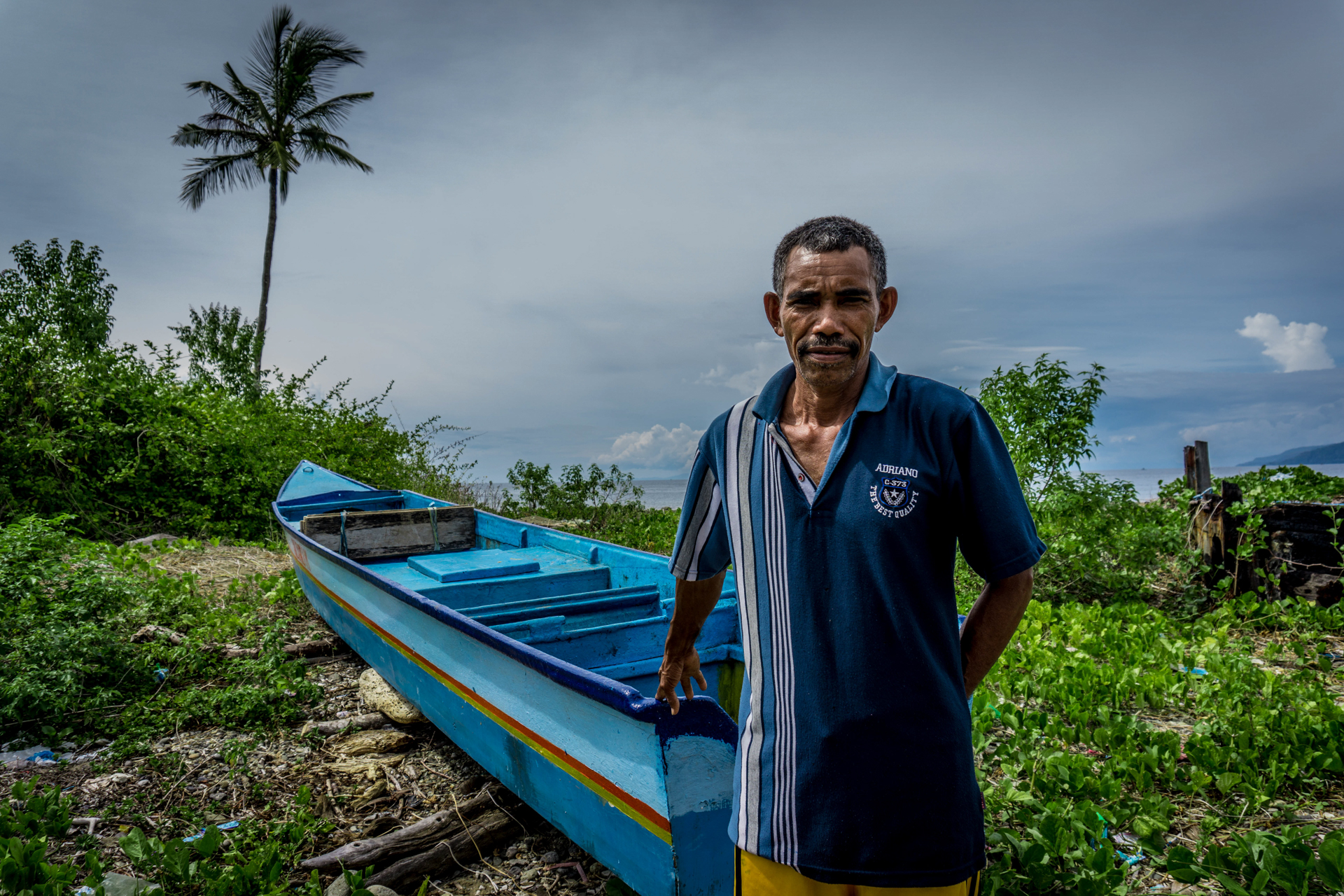Salsabila Makatika, 51, a tuna fisherman from Asilulu village on Ambon Island in eastern Indonesia, says catching fish has become increasingly unpredictable and dangerous. A fisherman in front of a boat and the sea