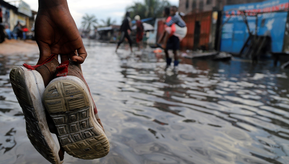 A Congolese man wades through floodwaters after the Congo River’s banks burst due to heavy rainfall in Kinshasa, Democratic Republic of Congo 9 January, 2020.