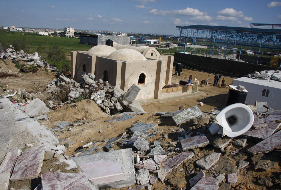 A new mud brick house stands next to the rubble of one of 4,036 homes destroyed in the January 2009 war between Israel and Hamas